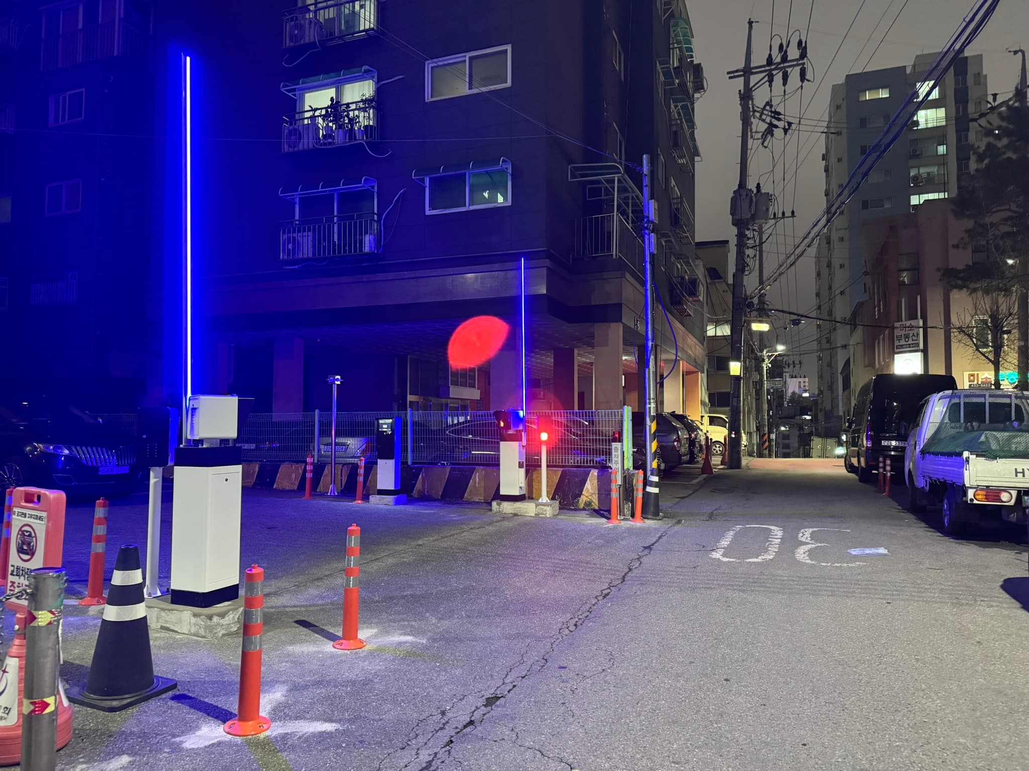 반대쪽 도로에서 바라본 출입구와 주변 건물. 도로를 따라 통과하는 차량과 옆으로 꺾어 들어오는 차량을 구분해야 하므로 양방향 접근 시야와 이동 방향을 함께 분석합니다.